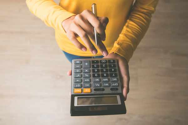 Overhead view of a person using a calculator Overhead view of a person using a calculator